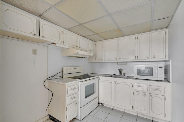 kitchen with a drop ceiling, white appliances, light tile patterned floors, and sink