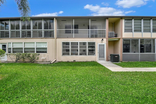 back of property featuring a lawn, cooling unit, and a balcony