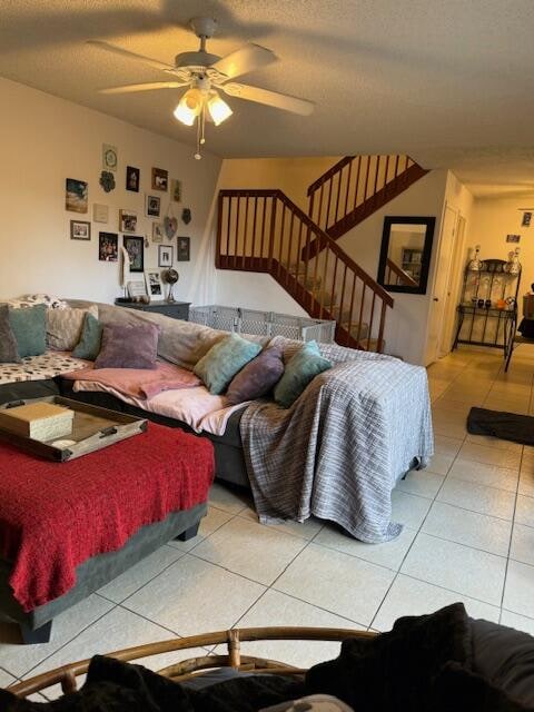 living room featuring a textured ceiling, tile patterned floors, and ceiling fan