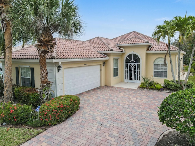 mediterranean / spanish house featuring french doors and a garage