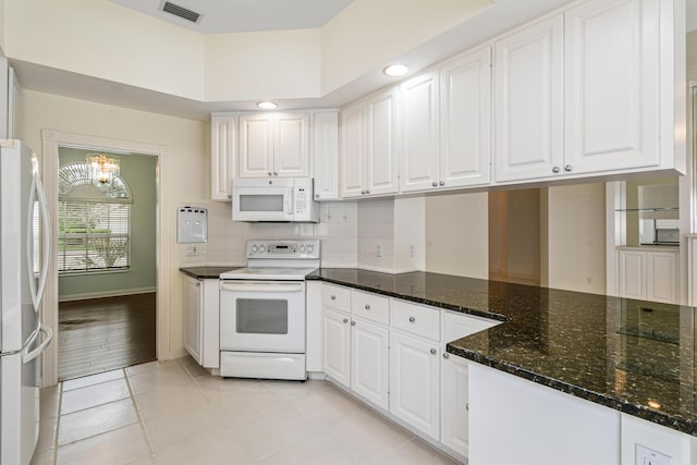 kitchen with white cabinets, light tile patterned floors, white appliances, and a chandelier