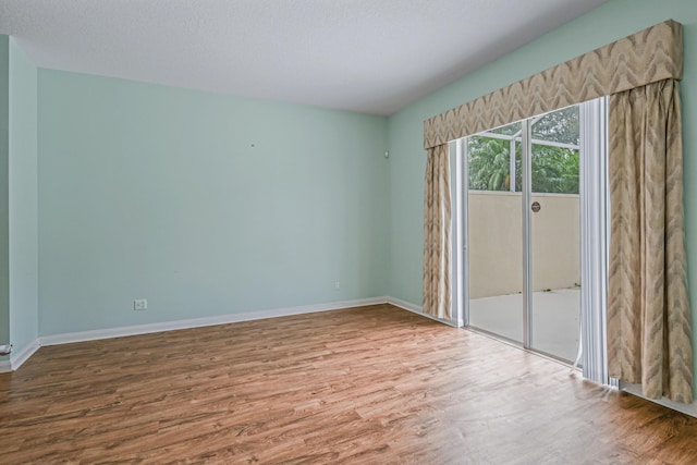 unfurnished room featuring hardwood / wood-style floors and a textured ceiling