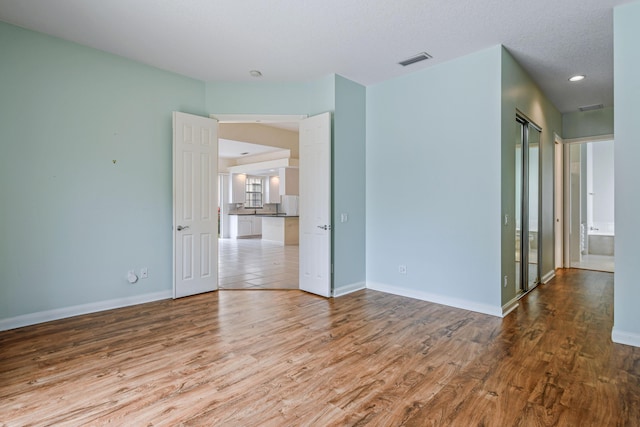 empty room featuring a textured ceiling and hardwood / wood-style flooring