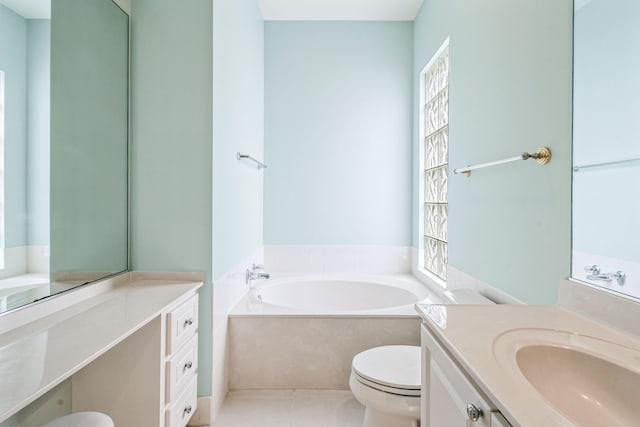 bathroom featuring tile patterned floors, a tub, vanity, and toilet