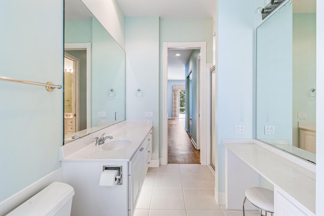 bathroom with tile patterned flooring, vanity, toilet, and walk in shower