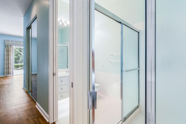 corridor with hardwood / wood-style floors and a textured ceiling