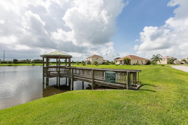 view of dock featuring a gazebo, a water view, and a yard