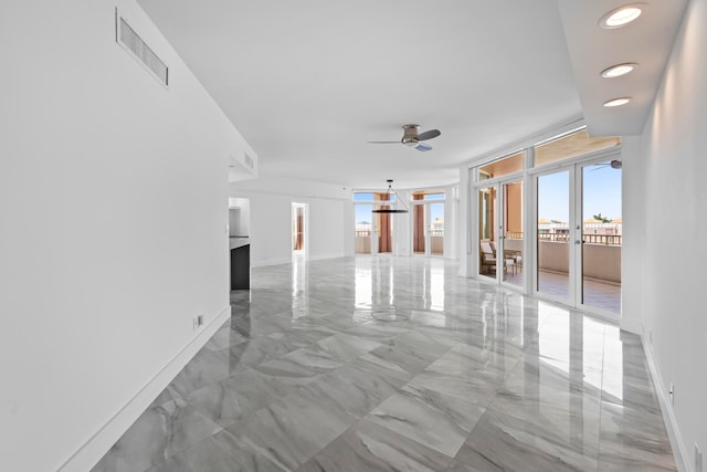 spare room with a wall of windows, light tile patterned flooring, and ceiling fan