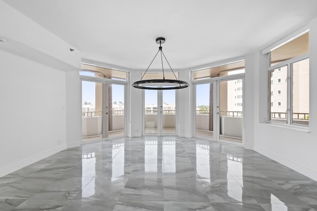 tiled empty room with a wall of windows, french doors, and a wealth of natural light