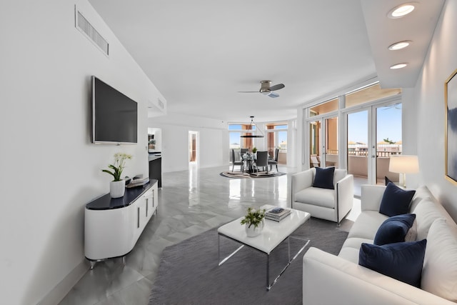 tiled living room with expansive windows, a healthy amount of sunlight, and ceiling fan