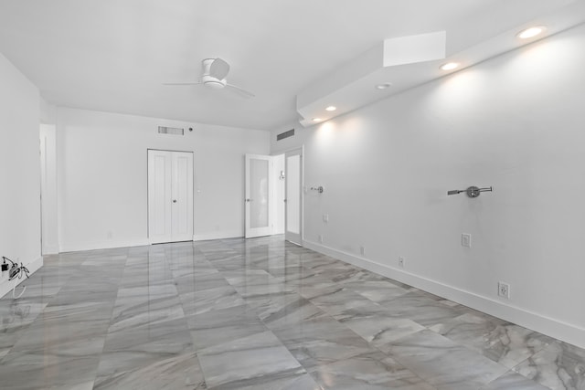 tiled spare room featuring ceiling fan