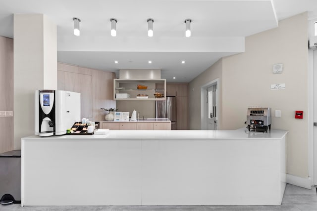 kitchen with stainless steel fridge, light tile patterned flooring, kitchen peninsula, and light brown cabinets