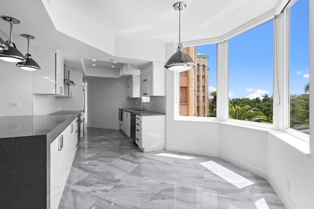 kitchen featuring tasteful backsplash, pendant lighting, light tile patterned flooring, white cabinetry, and a raised ceiling