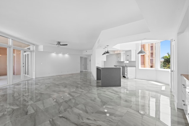 unfurnished living room featuring light tile patterned flooring and ceiling fan