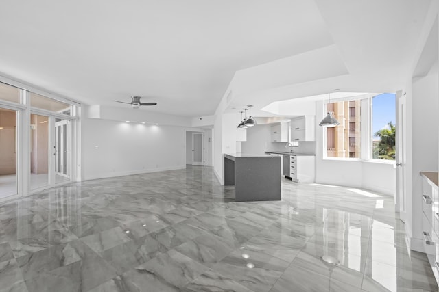 300 SE 5th Ave Unit 5180, Boca Raton, FL 33432 - unfurnished living room featuring light marble finish floors, a ceiling fan, and baseboards