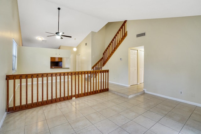 unfurnished room with high vaulted ceiling, ceiling fan, and light tile patterned flooring