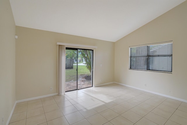 spare room with light tile patterned flooring and vaulted ceiling