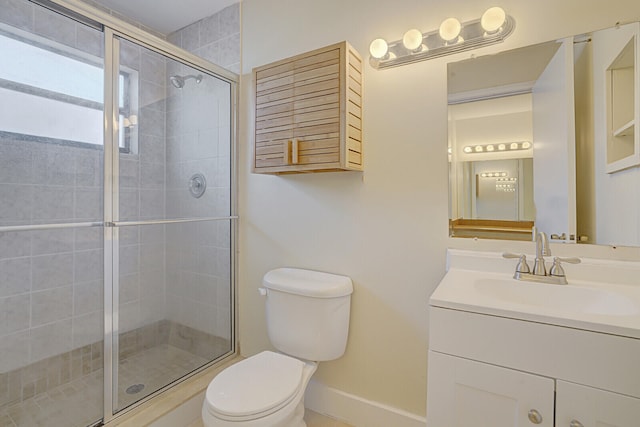 bathroom featuring toilet, vanity, and an enclosed shower