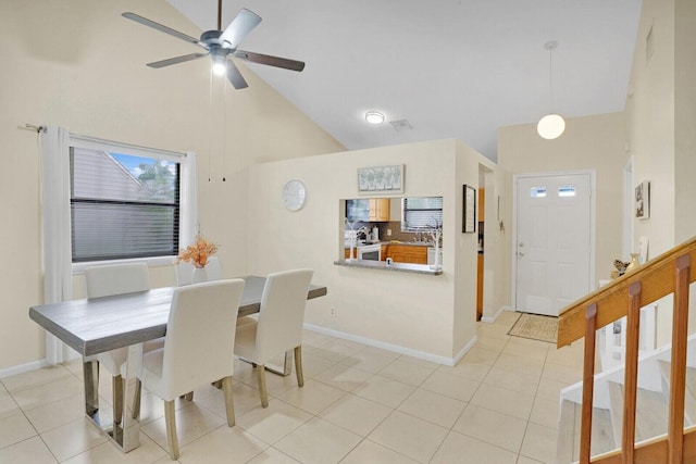 dining area with high vaulted ceiling, light tile patterned floors, and ceiling fan