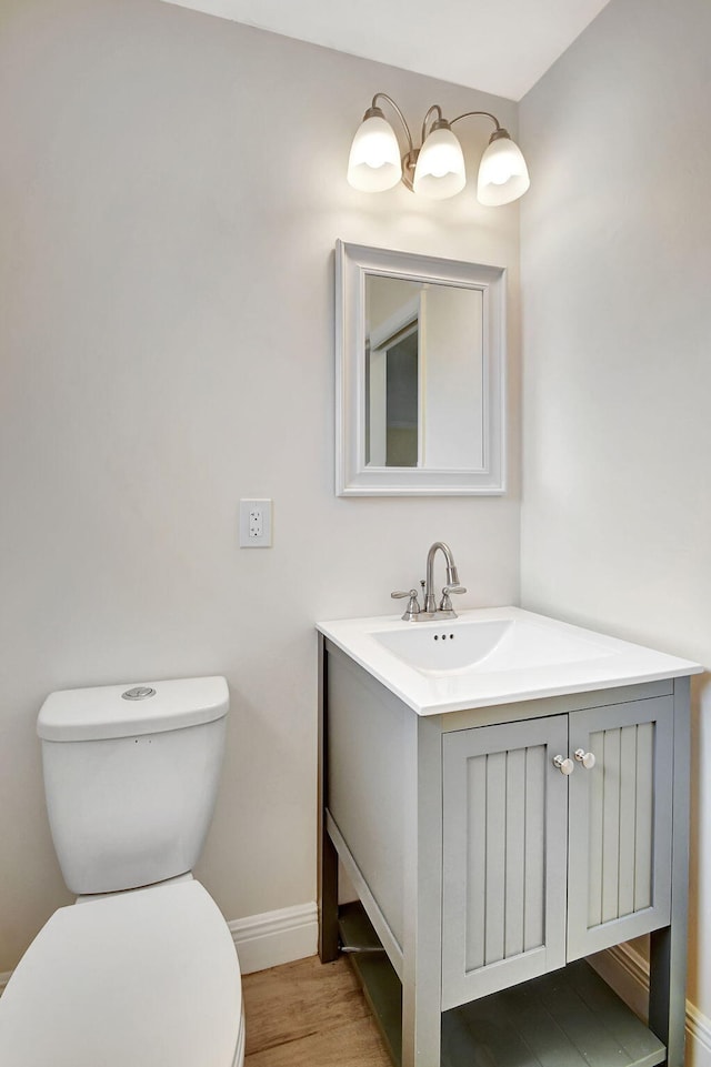 bathroom with hardwood / wood-style flooring, vanity, and toilet