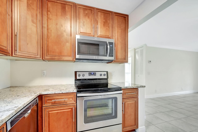 kitchen with light stone countertops, stainless steel appliances, and light tile patterned floors