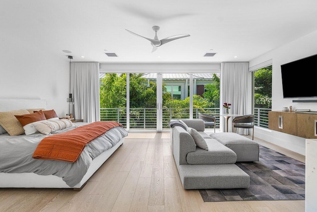 bedroom featuring access to exterior, multiple windows, visible vents, and wood finished floors