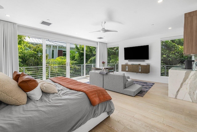 bedroom with multiple windows, light hardwood / wood-style flooring, and ceiling fan