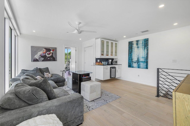 living room featuring wine cooler, recessed lighting, visible vents, baseboards, and light wood finished floors