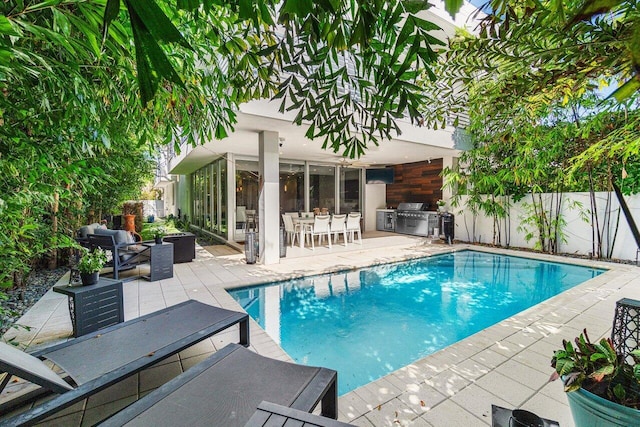 view of pool with a patio area, fence, a fenced in pool, and area for grilling