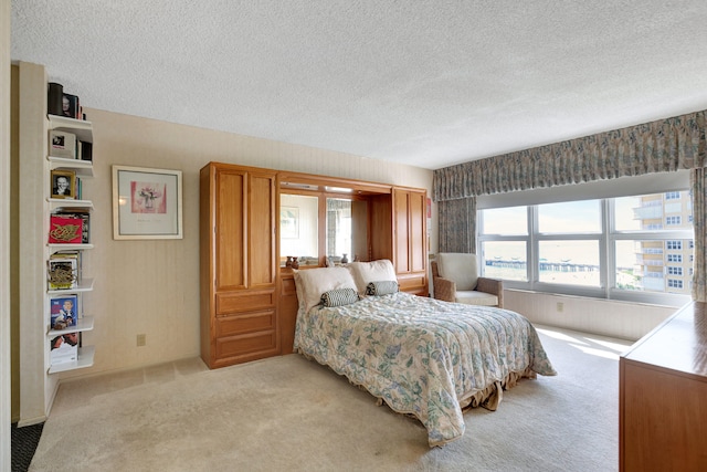 bedroom with a textured ceiling and light colored carpet