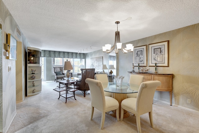 dining space featuring rail lighting, light carpet, and a textured ceiling