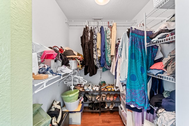 walk in closet with hardwood / wood-style flooring