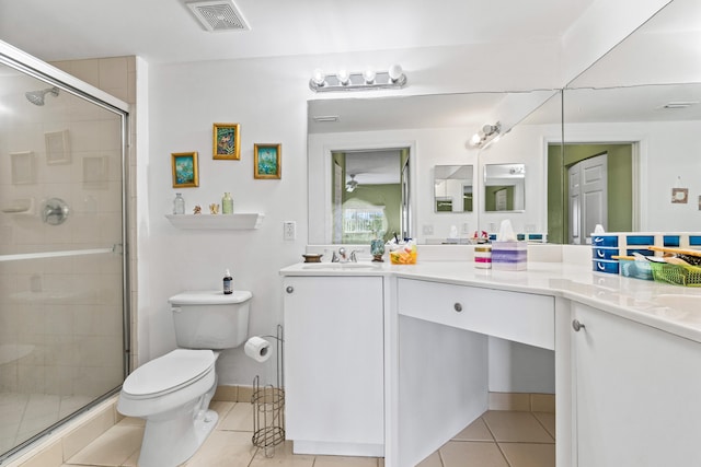 bathroom with tile patterned flooring, dual vanity, a shower with shower door, and toilet