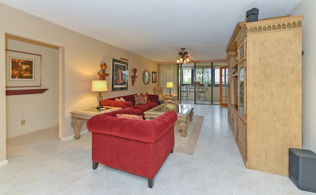 living room featuring light tile patterned floors, baseboards, a ceiling fan, and a textured ceiling