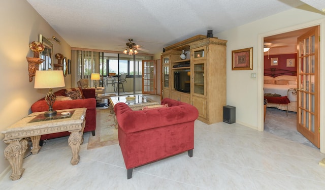 living area featuring a sunroom, ceiling fan, a textured ceiling, and light tile patterned floors