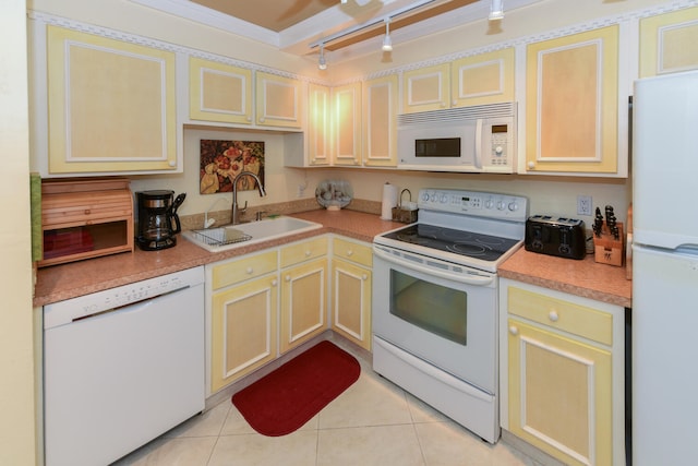 kitchen with white appliances, light countertops, a sink, and light tile patterned floors