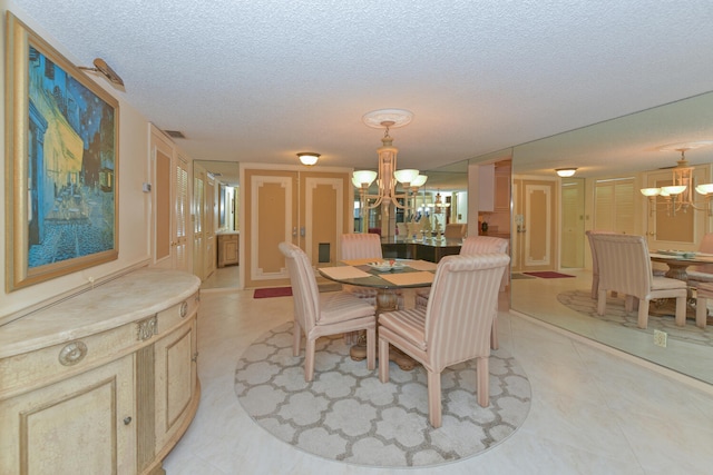 dining area with an inviting chandelier, light tile patterned floors, visible vents, and a textured ceiling