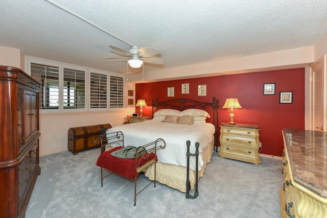 bedroom with light carpet, a textured ceiling, and ceiling fan