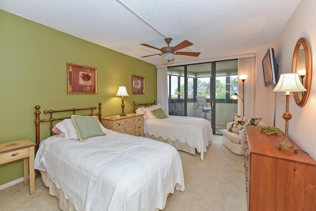 carpeted bedroom featuring access to outside, a textured ceiling, and ceiling fan