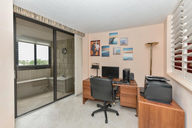 office area with light tile patterned floors and a textured ceiling