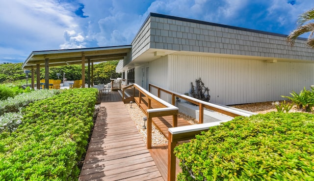 view of side of property with a deck and mansard roof