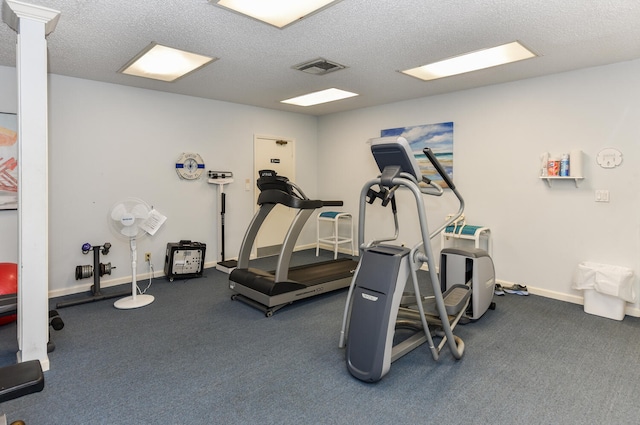 workout area with visible vents, baseboards, and a textured ceiling