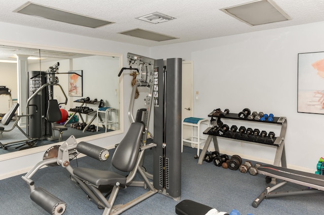 exercise area with attic access, visible vents, and a textured ceiling