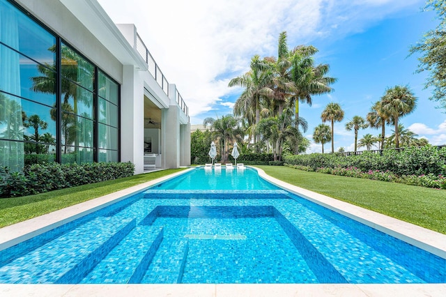 view of pool featuring a lawn