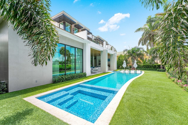 view of pool featuring a lawn and a patio