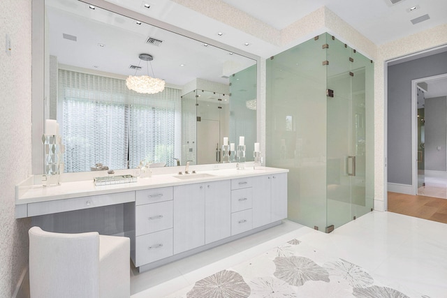 bathroom featuring hardwood / wood-style floors, an inviting chandelier, vanity, and a shower with shower door