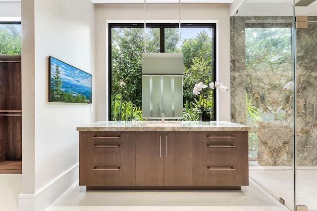 bar featuring dark brown cabinets, sink, and a healthy amount of sunlight