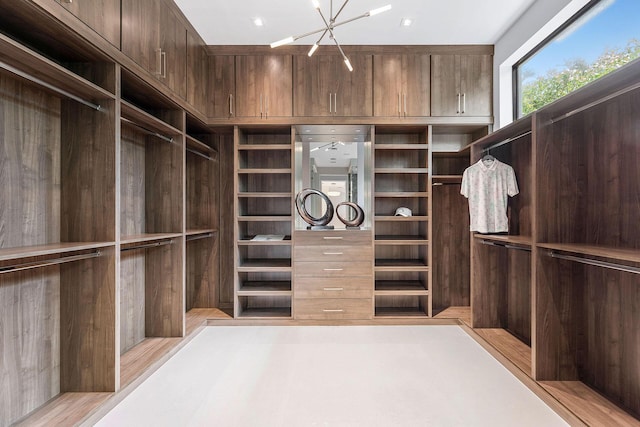 spacious closet with an inviting chandelier