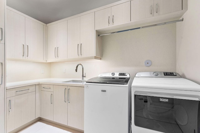 laundry area with cabinets, washer and dryer, and sink