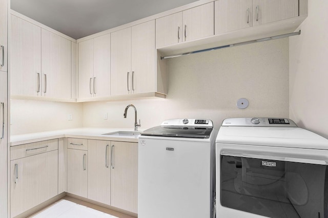 laundry room with cabinets, light tile patterned floors, independent washer and dryer, and sink